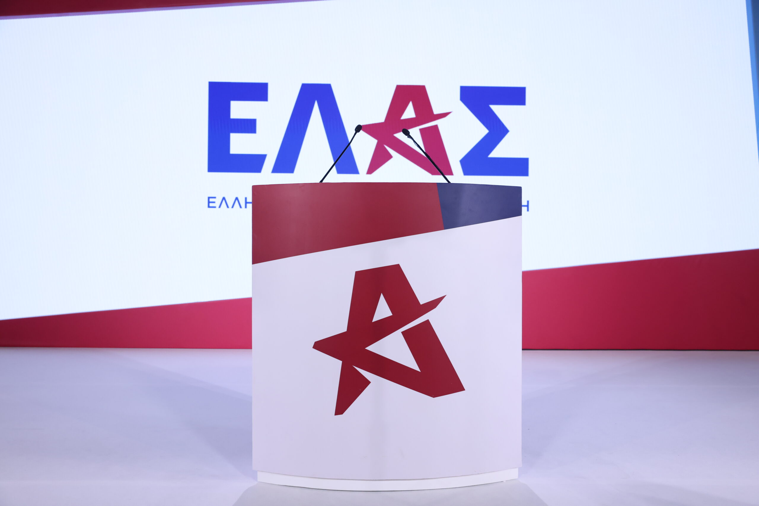 Βήμα ομιλητή και φόντο με το έμβλημα της ΕΛ.Α.Σ.