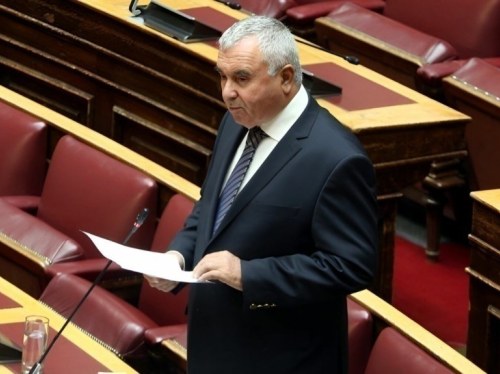 Ο Σταύρος Μιχαηλίδης μιλά κρατώντας σημειώσεις στην αίθουσα της Βουλής.